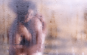man and woman hugging behind shower door